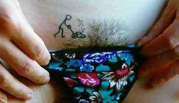 picture of a woman with a tatoo of a man moving the grass by her pubic hair